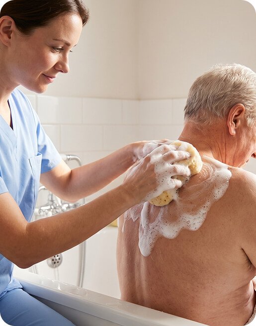 Carer helping an older man wash his back