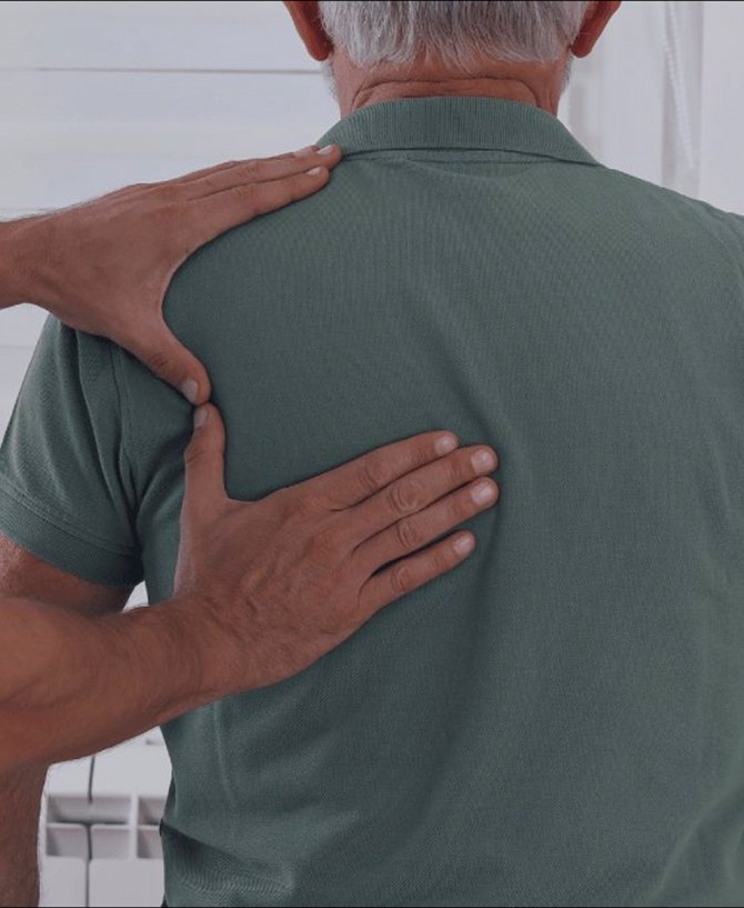 Physiotherapist assessing an older man’s back