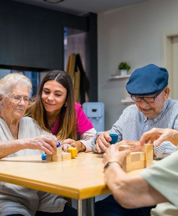 Support worker playing a board game with older people