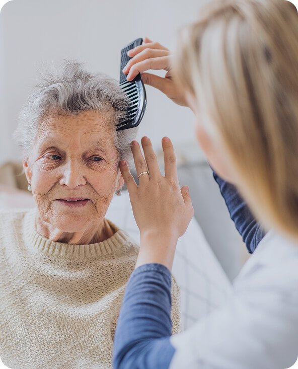 Carer brushing an older woman’s hair