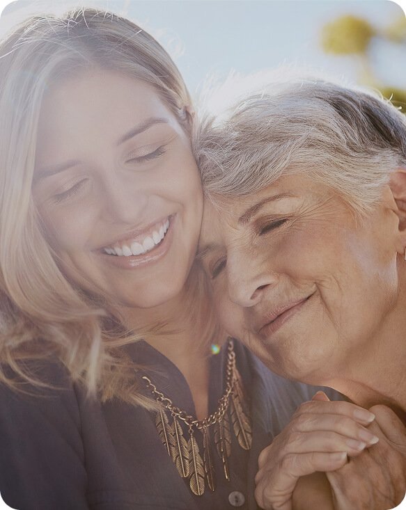 Younger woman and older woman smiling cheek to cheek
