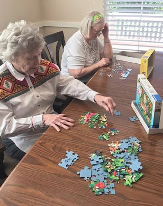 Older people completing a jigsaw puzzle together
