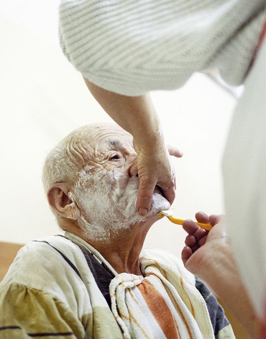 Carer helping an older man take his medication