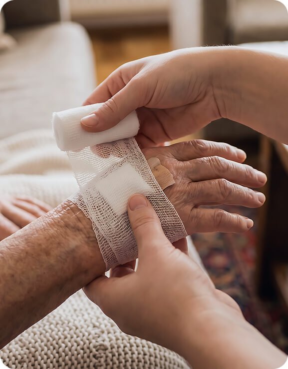 Carer bandaging an older person’s hand